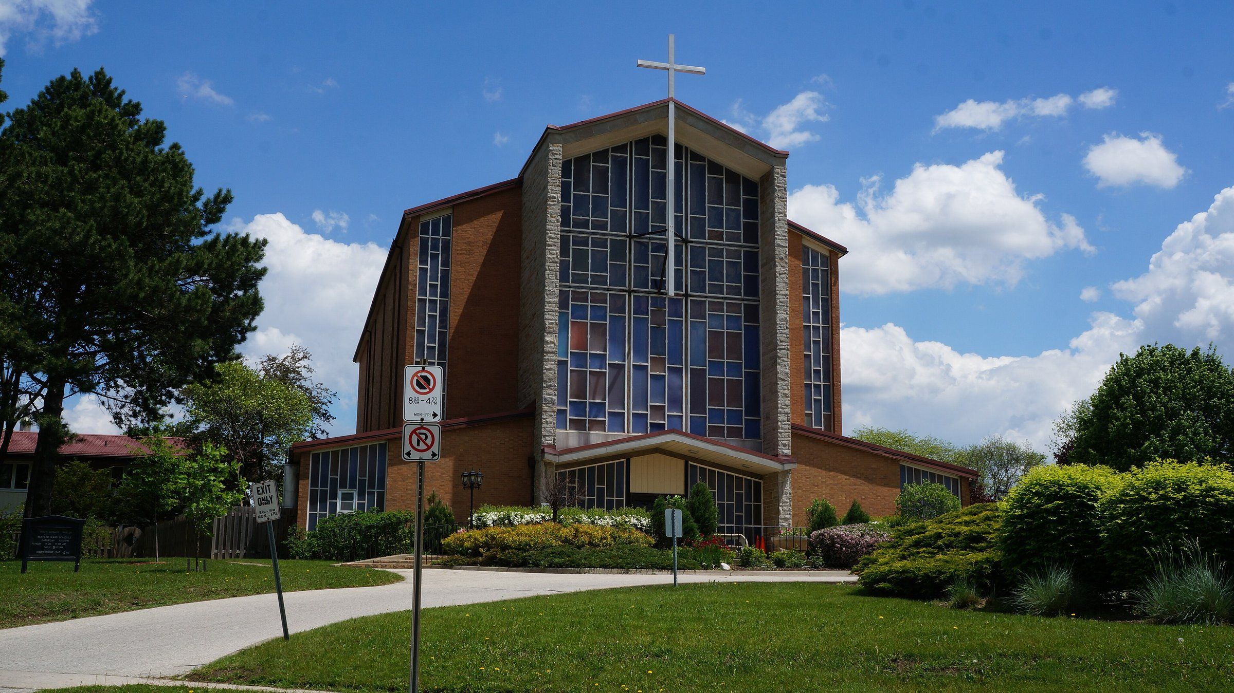 Holy Rosary Catholic Church, a brick church with a tall stained-glass front and a cross